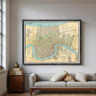 a large framed map of New Orleans hanging on a wall above a gray couch with pillows.