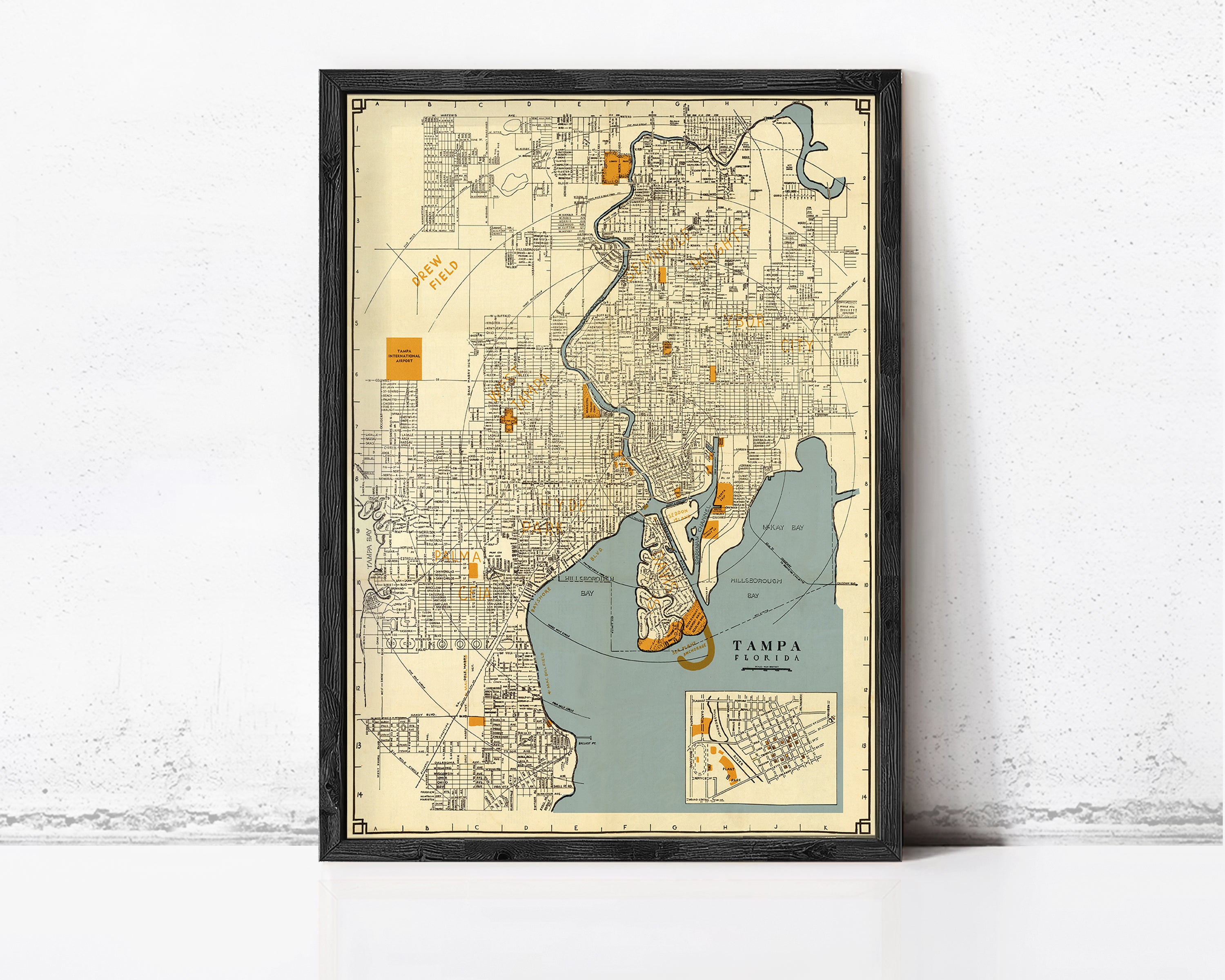 The image is a framed vintage map of Tampa, Florida, depicting the city's streets, landmarks, and surrounding areas.