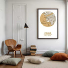 a cozy living room with a wooden chair, a floor lamp, and a framed map of Osaka. The room has a minimalist and modern design, with a white wall and a beige carpet.