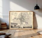 The image is a framed vintage map of a city, depicting various landmarks and streets.