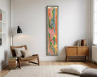 A colorful, abstract painting or artwork is displayed on a white wall, featuring a vertical arrangement of vibrant, swirling shapes and lines.