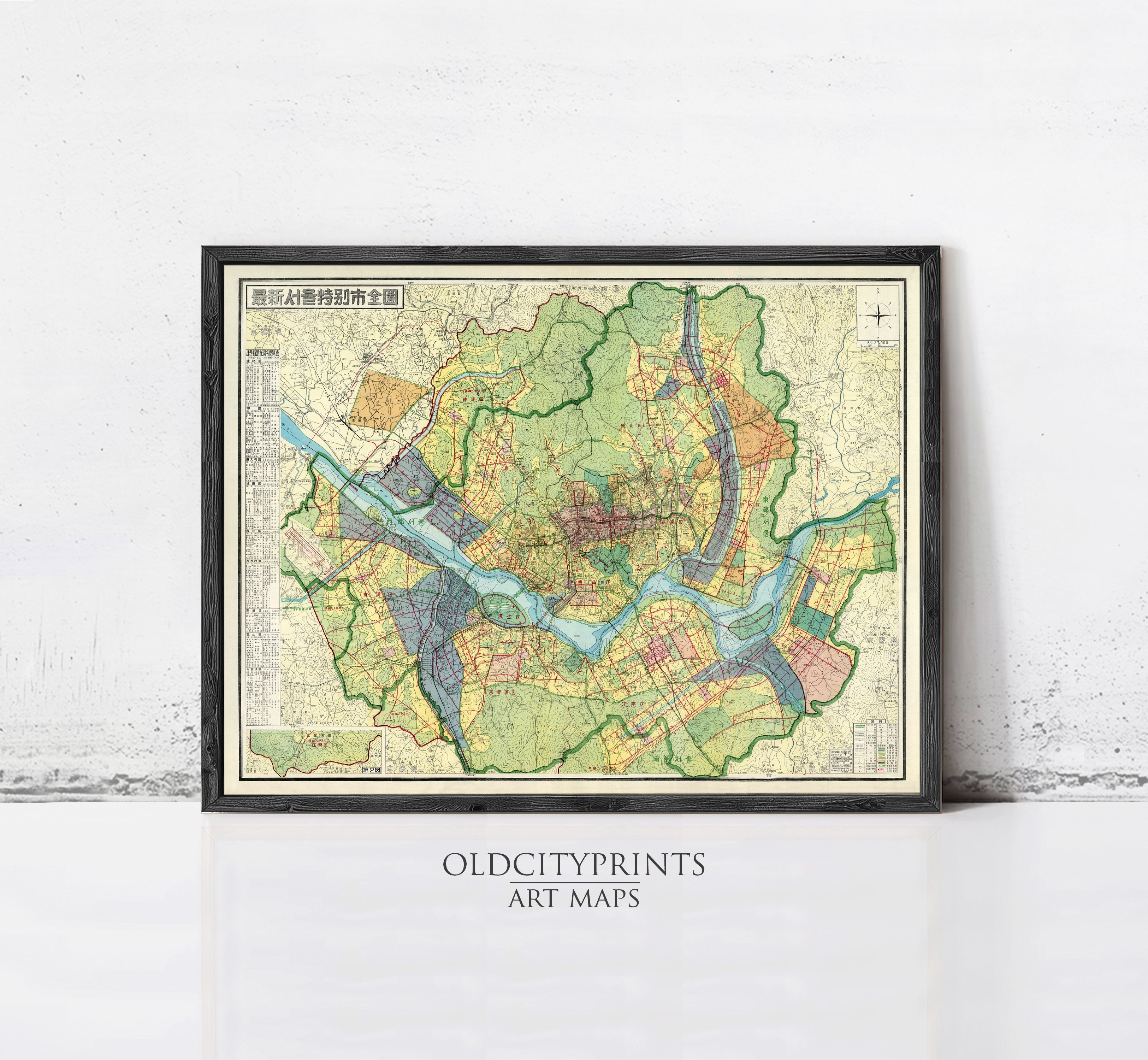 The image is a framed art print depicting a detailed map of a city or region, with various colored lines and symbols representing roads, rivers, and other geographical features.