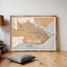 a large framed map of Quebec, Canada, with a wooden floor and a stack of books in the foreground.