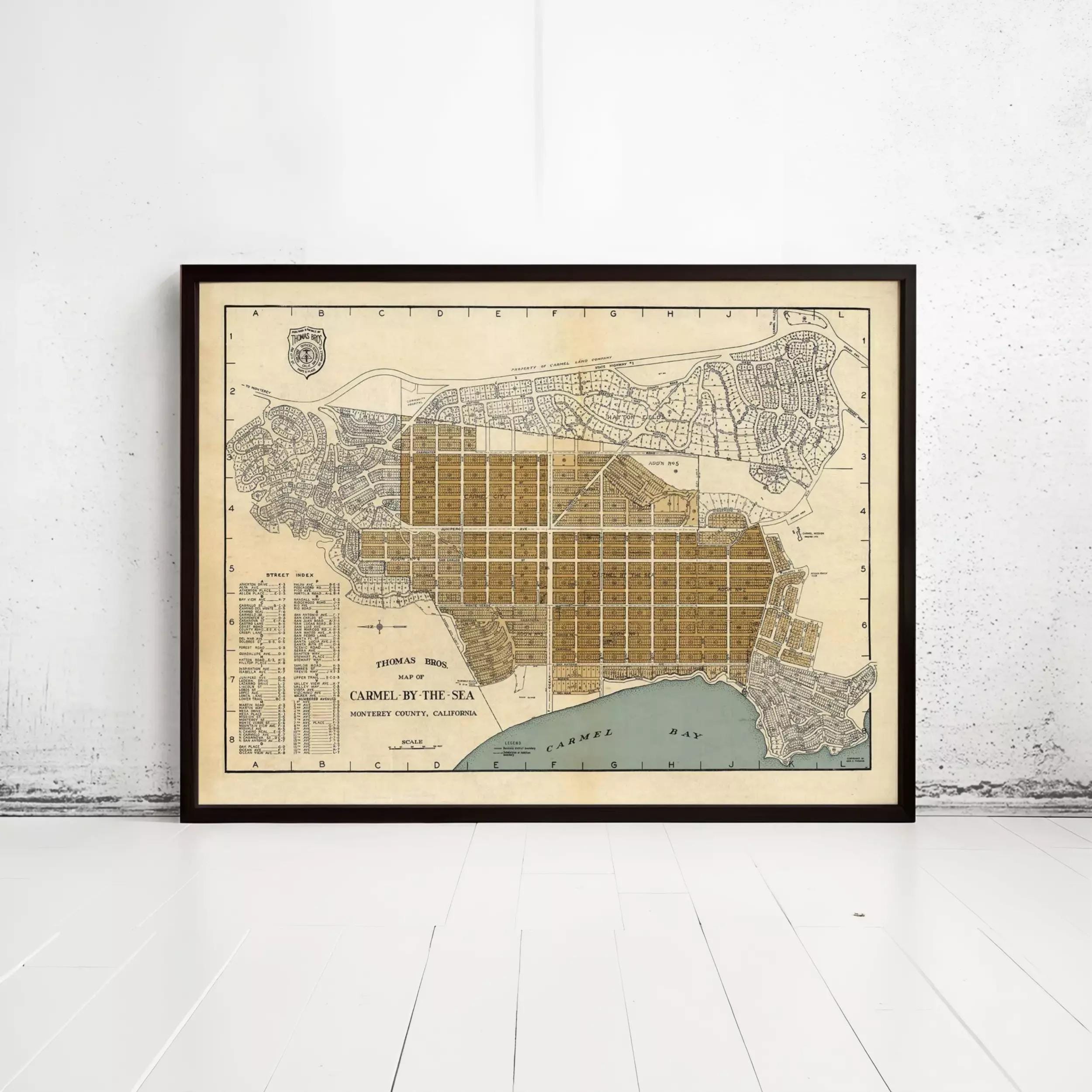 The image is a framed vintage map of Carmel by the Sea, showing the city's layout and surrounding areas.