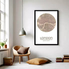 a cozy living room with a large framed map of London hanging on the wall, a wooden chair, a stack of books, and a pendant light.