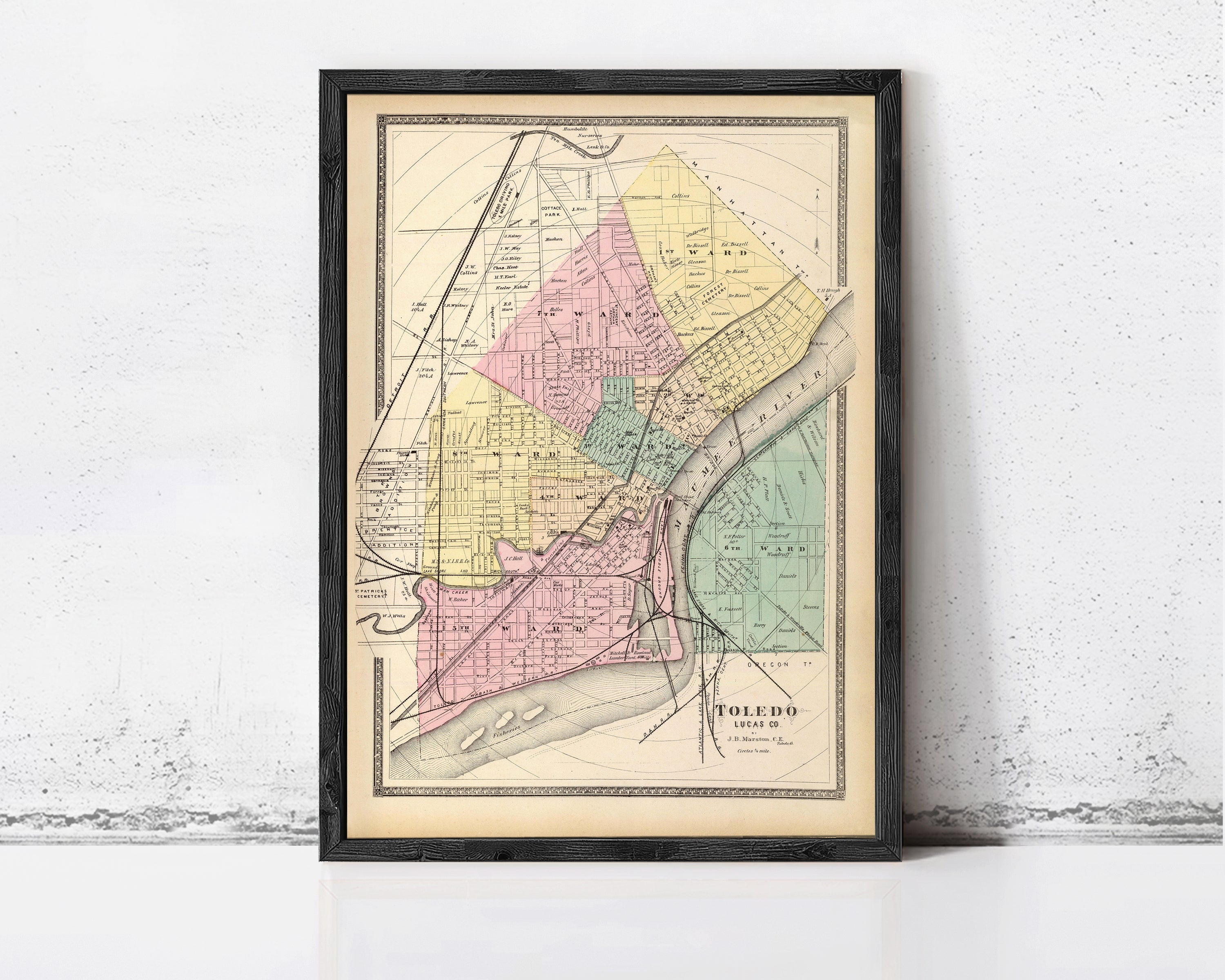 The image is a framed vintage map of the city of Toledo, Ohio, depicting the city's streets and neighborhoods in a detailed and colorful manner.