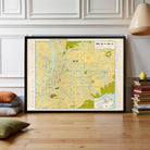 a large framed map of Taipei City, Taiwan, with a wooden floor and a stack of books to the right.