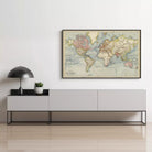 a large world map hanging on a wall above a gray cabinet or entertainment center.