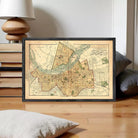 The image is a framed vintage map of a city, depicting streets, landmarks, and other geographical features.