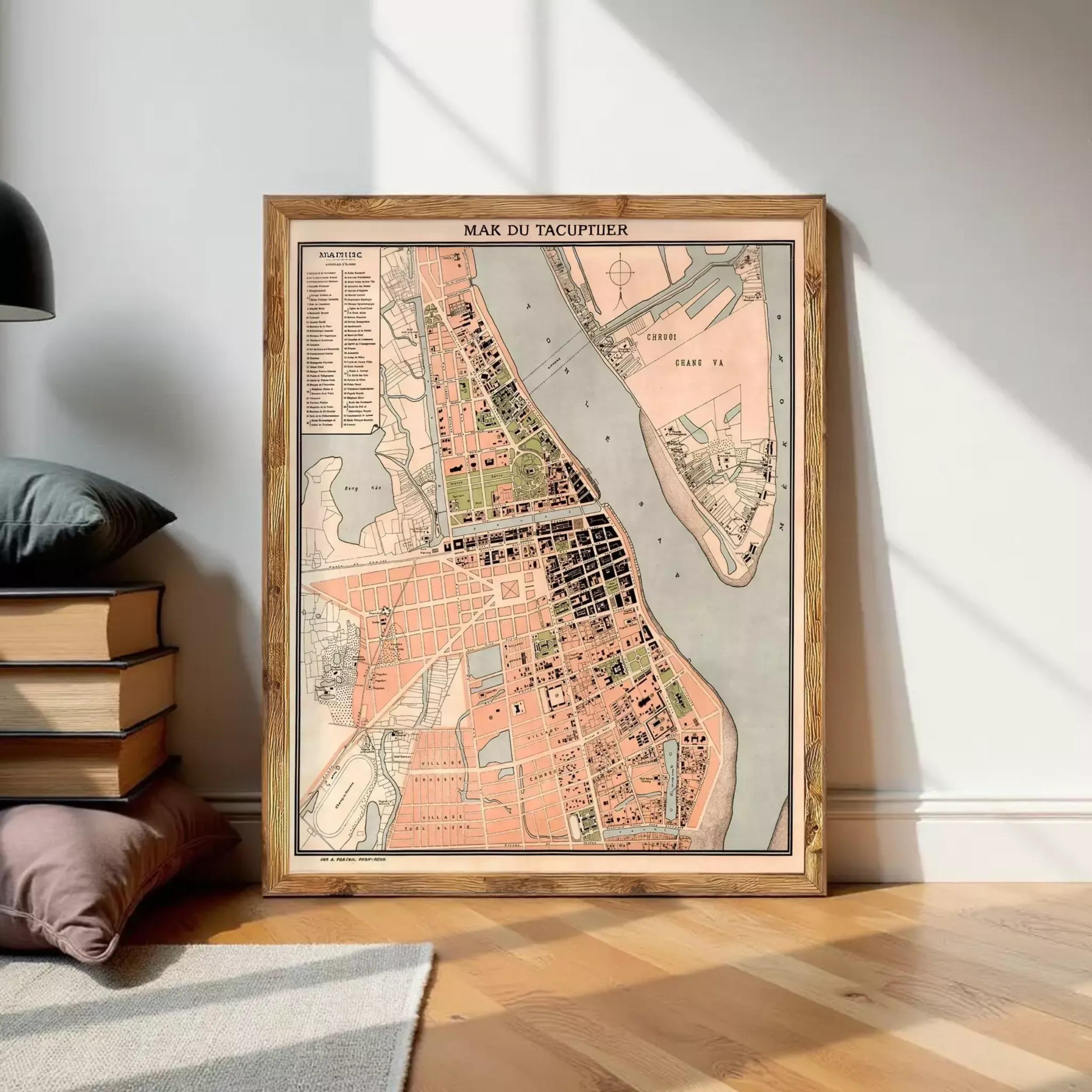 a framed map of a city, with a wooden floor and a stack of books visible in the background.