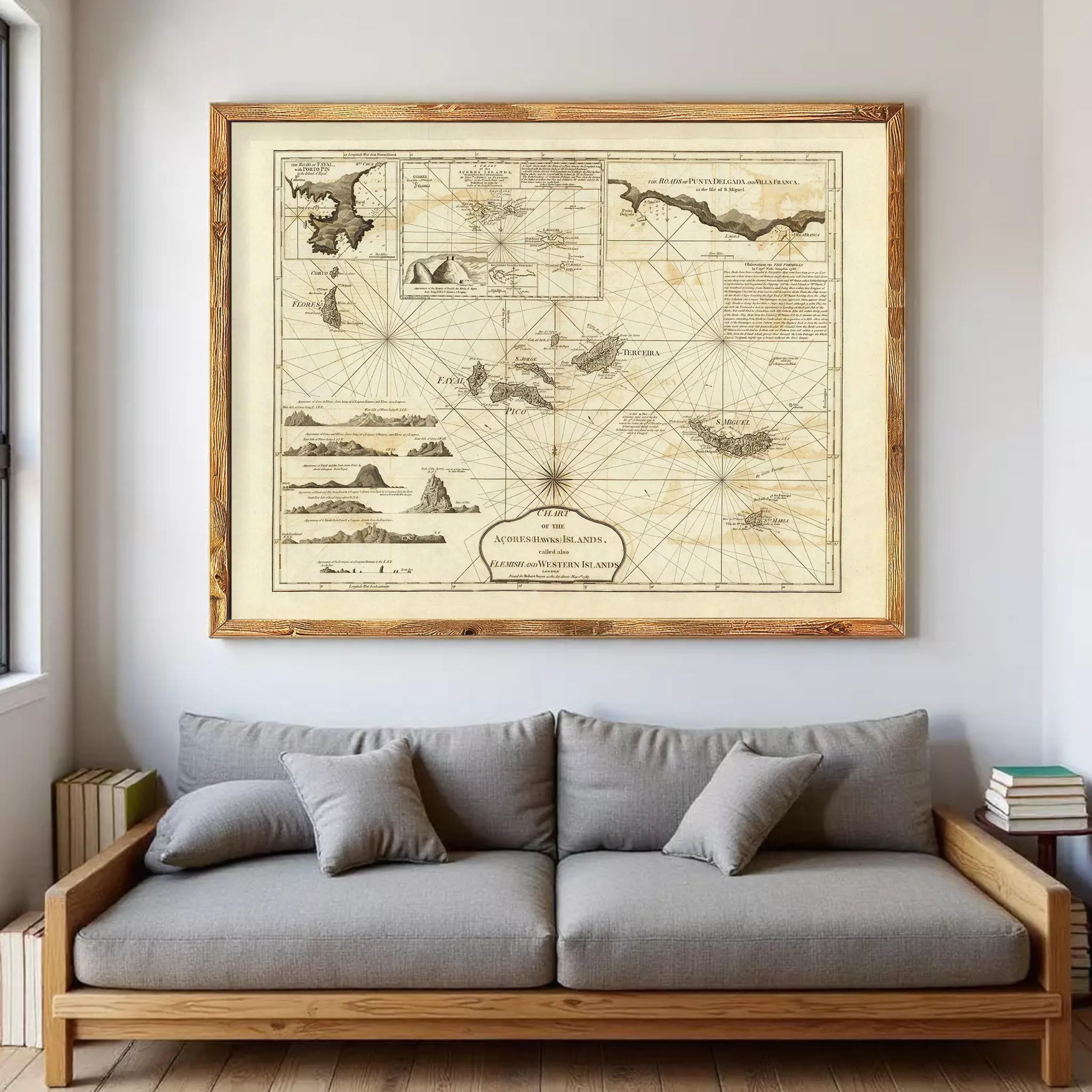 a large, framed map of the Caribbean Sea hanging on a wall above a gray sofa.