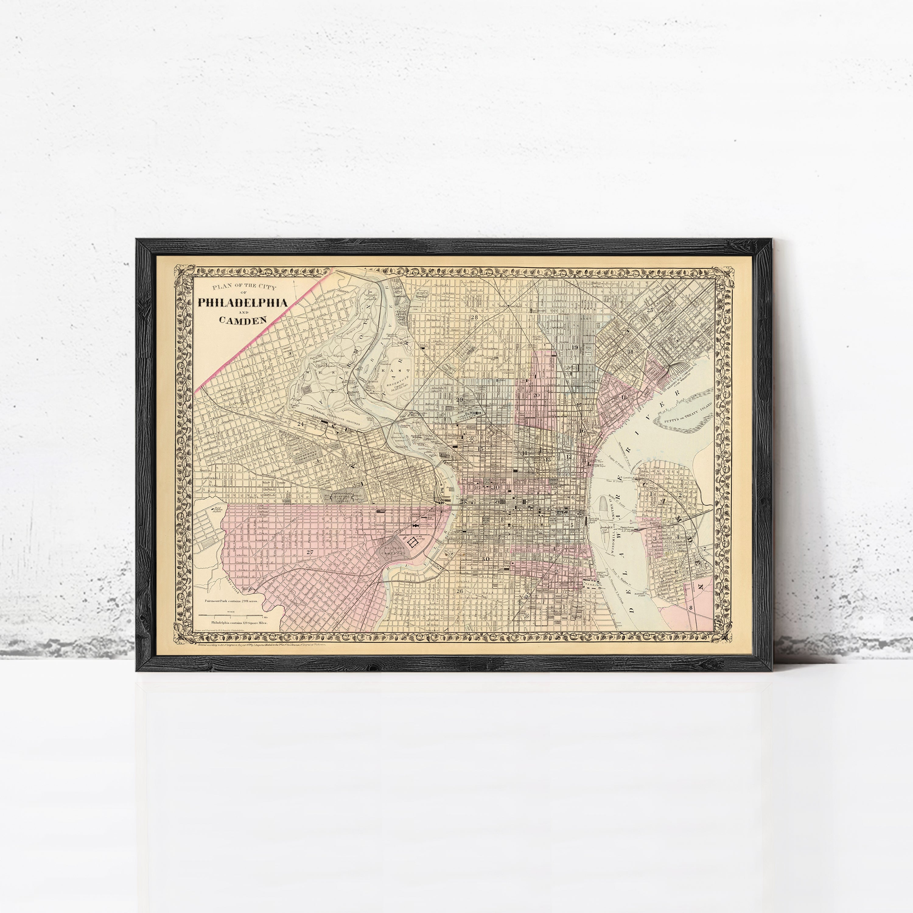 The image is a framed vintage map of Philadelphia, Pennsylvania, depicting the city's streets and neighborhoods.