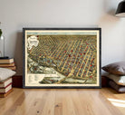 The image is a framed vintage map of a city, depicting a densely populated urban area with numerous buildings and streets.
