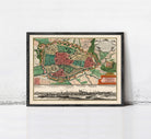 The image is a framed vintage map of a city, depicting a detailed layout of streets, buildings, and other urban features.