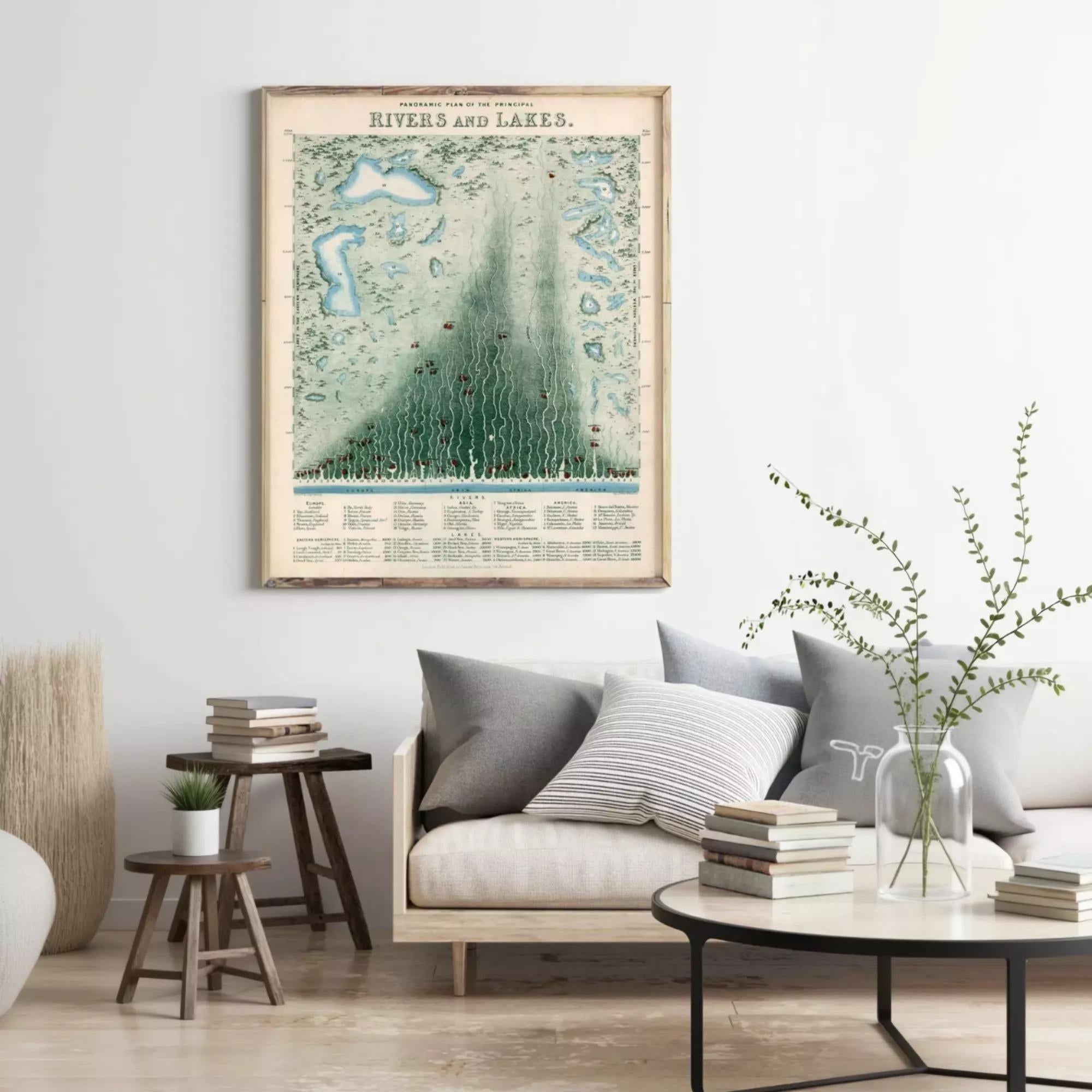a living room with a large framed map of rivers and lakes hanging on the wall above a couch with pillows. There are also some books and a vase on a table in the room.