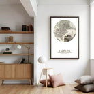 a cozy living room with a wooden bookshelf, a lamp, and a framed map of Naples hanging on the wall.
