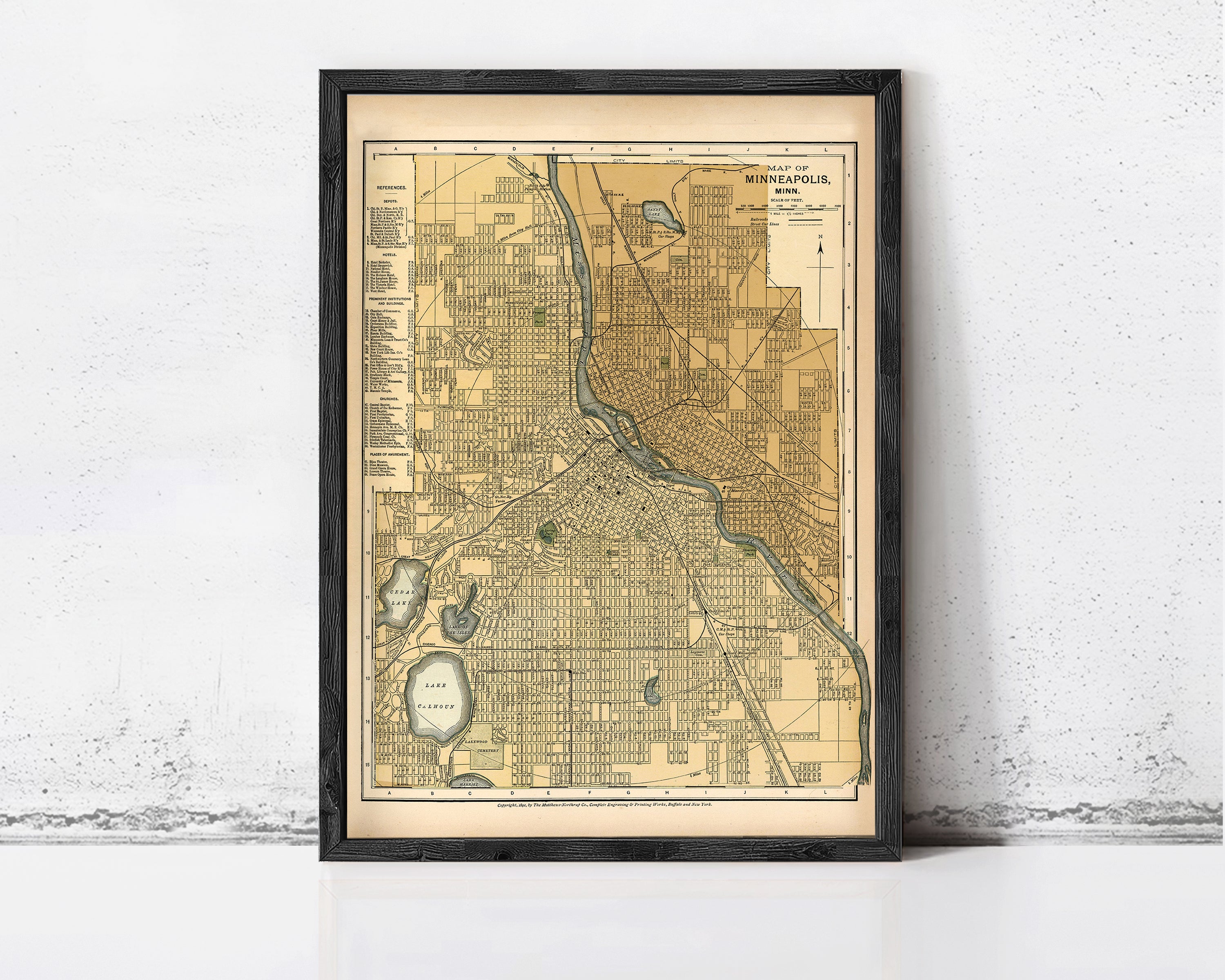 The image is a framed map of Minneapolis, Minnesota, depicting the city's streets and surrounding areas.
