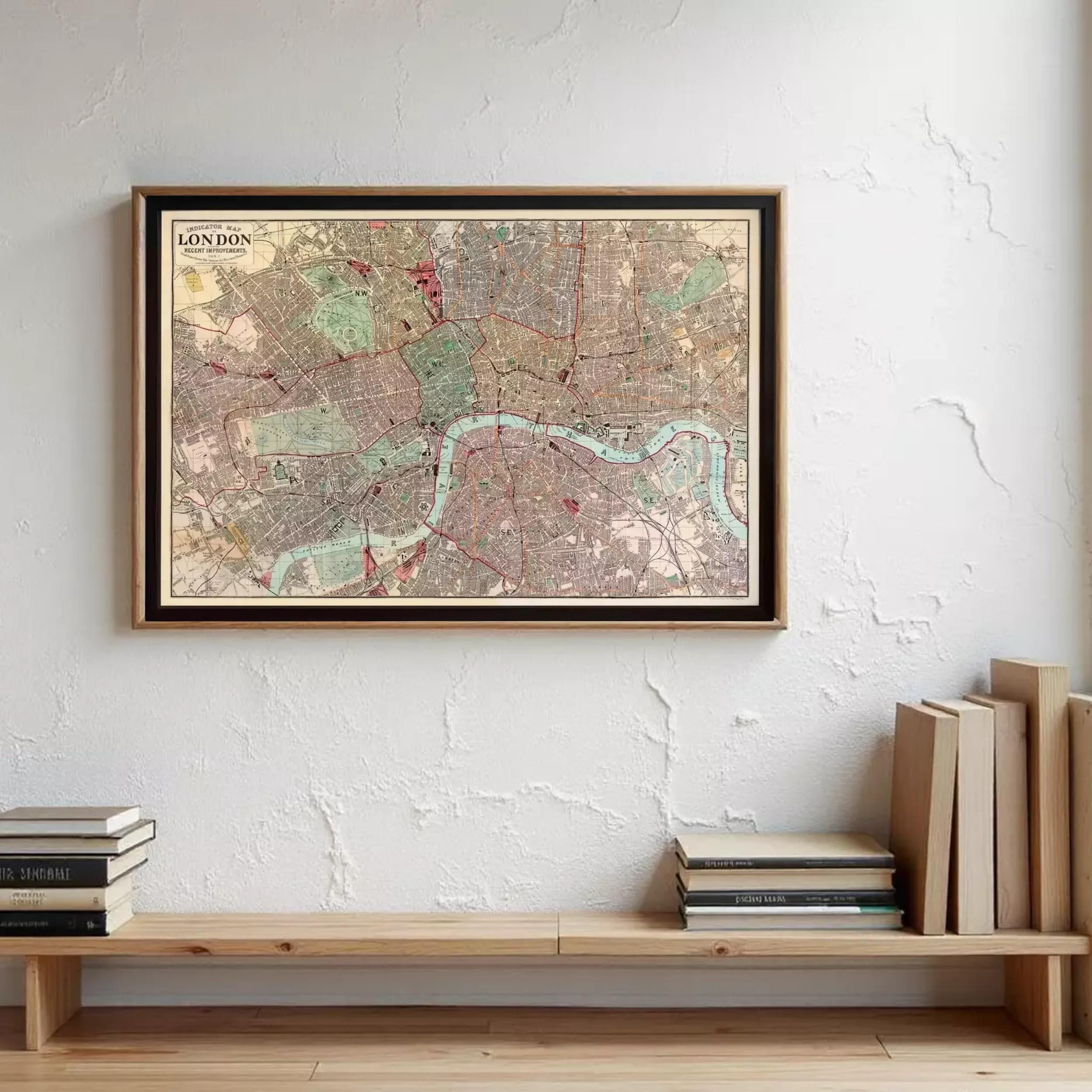 A framed map of London is hanging on a wall, with a wooden shelf below it holding several books.