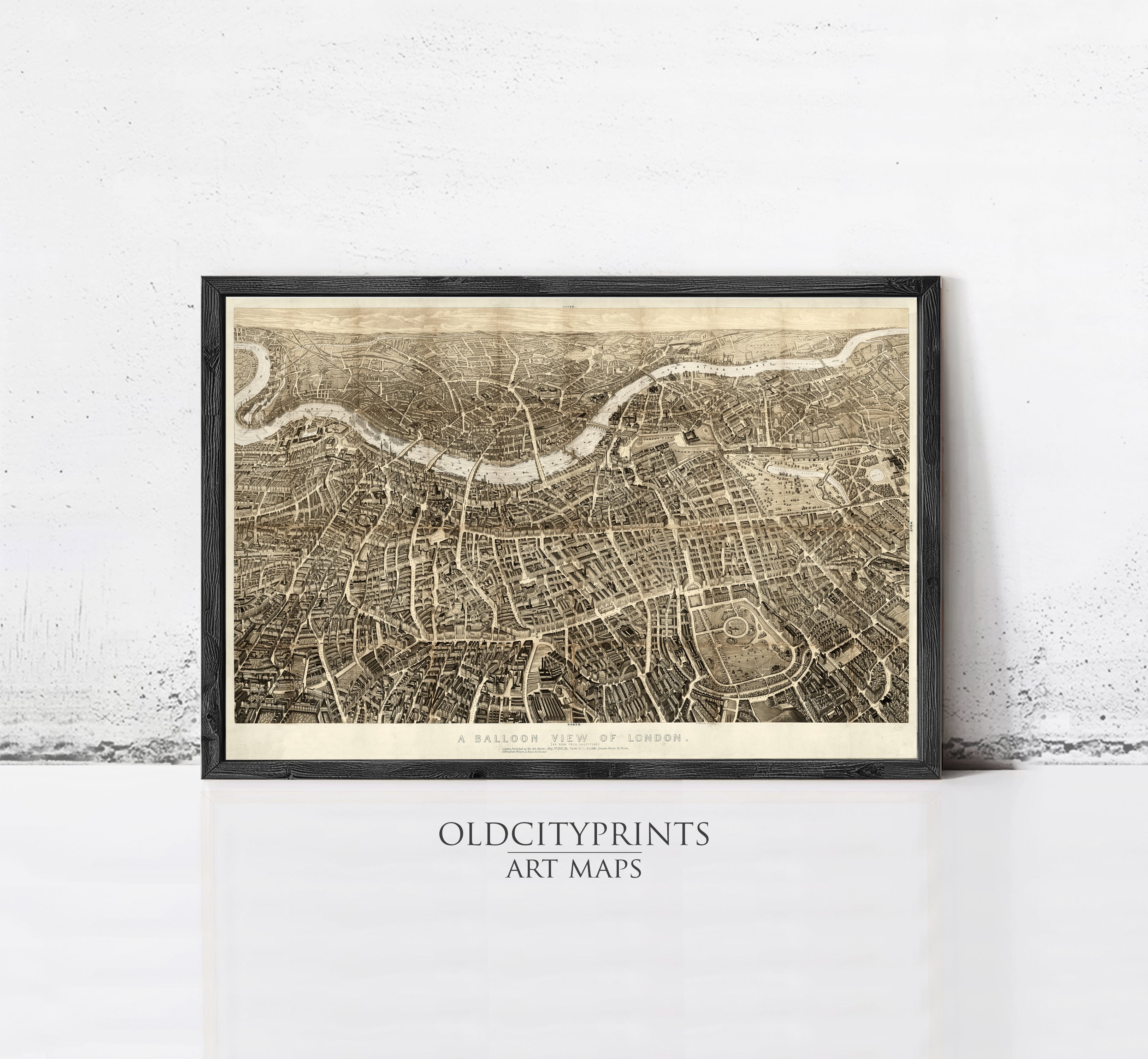 A framed antique map of London, depicting the city's layout and streets, is displayed on a white wall.