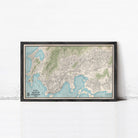 The image is a framed map of a city, likely a coastal city, with a detailed and intricate layout of streets, landmarks, and bodies of water.