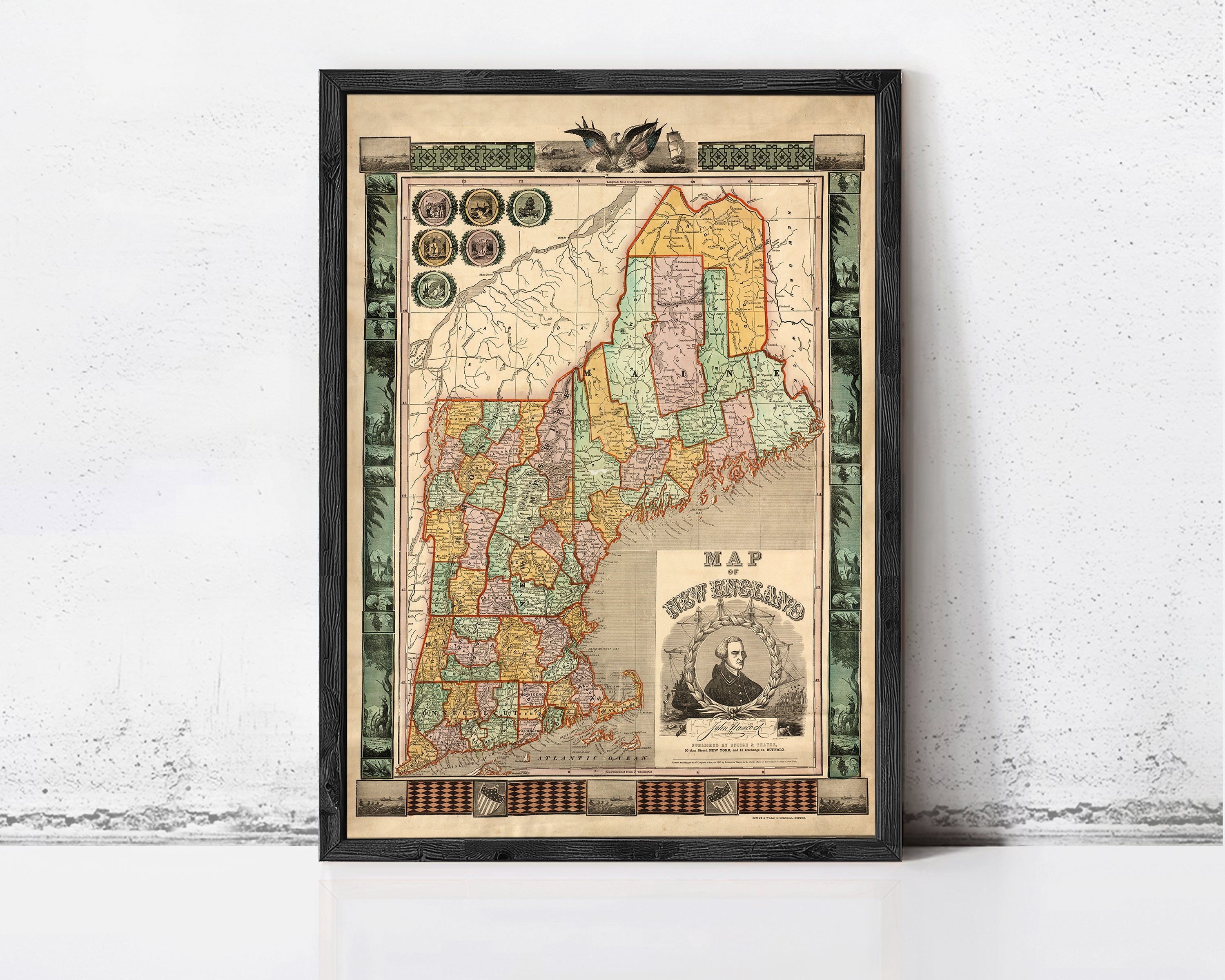 The image is a framed vintage map of New England, depicting the region in a detailed and colorful manner.
