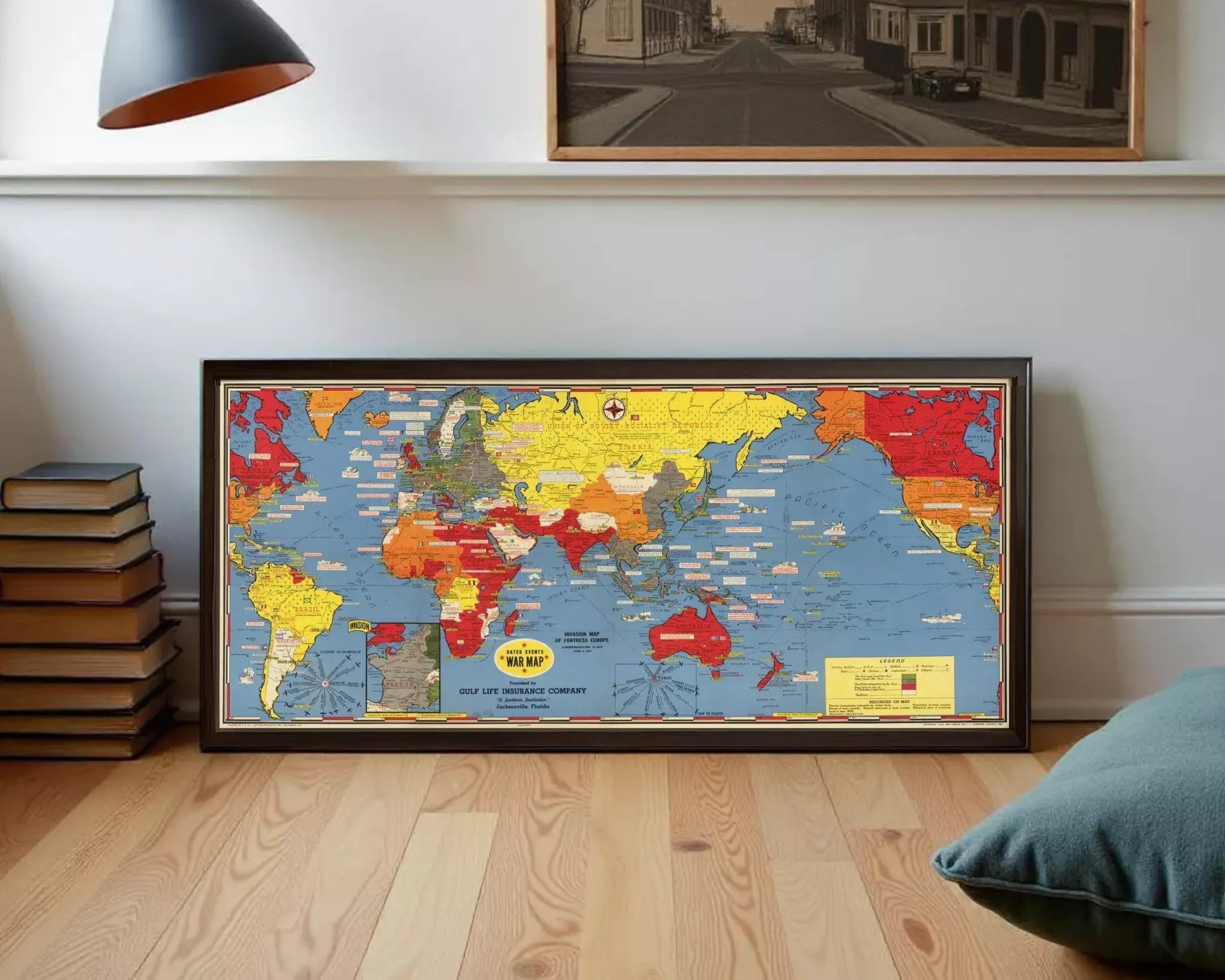 A framed vintage world map with colorful country borders and labels, displayed on a white wall.