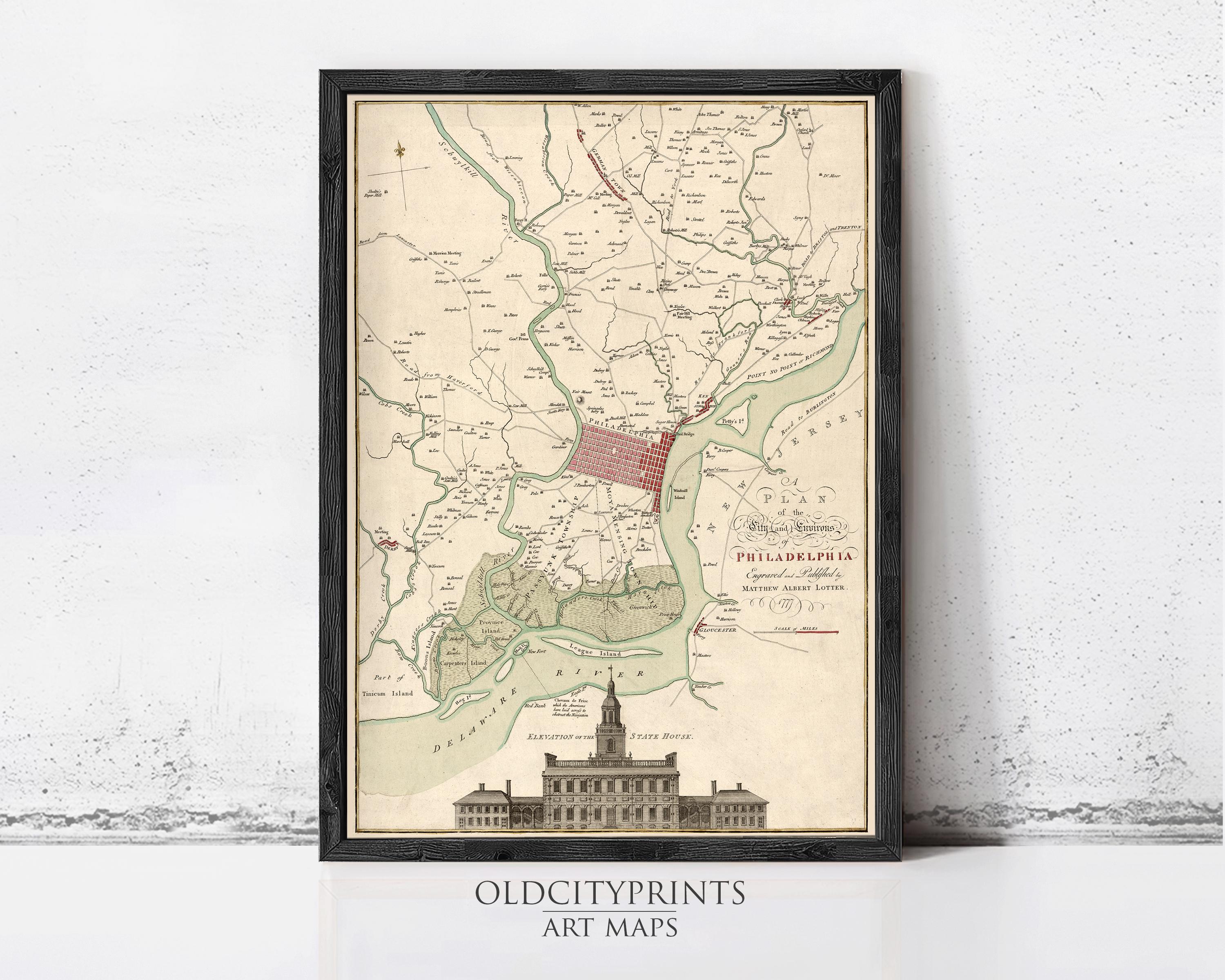 The image is a framed vintage map of Philadelphia, Pennsylvania, depicting the city's streets, landmarks, and surrounding areas.