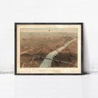 The image is a framed aerial view of a city, depicting a river or canal running through the center of the city.