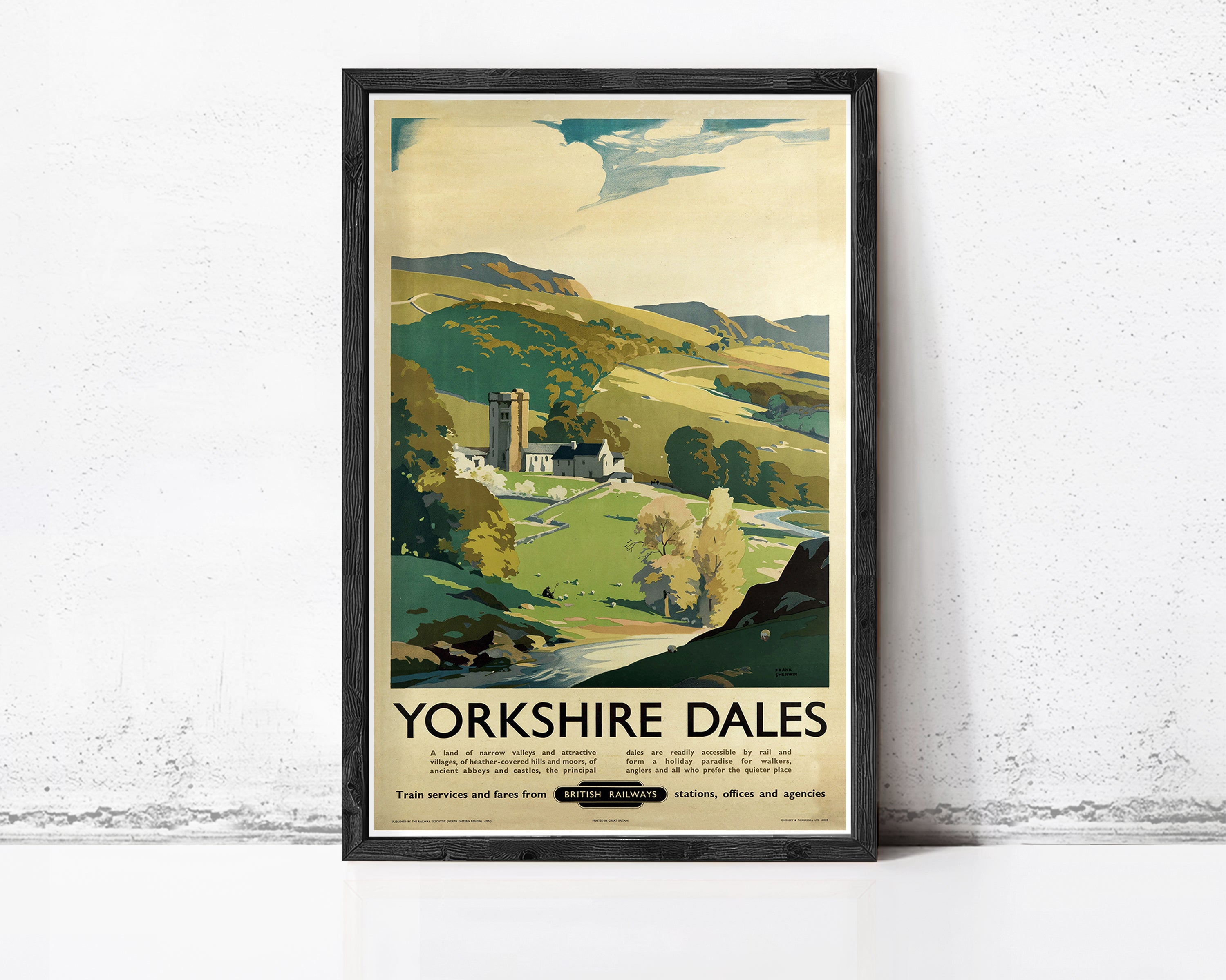 A framed vintage travel poster advertising Yorkshire Dales, featuring a scenic countryside landscape with a church, trees, and a winding river.
