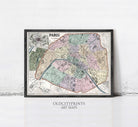 The image is a framed vintage map of Paris, France, depicting the city's streets and neighborhoods in a detailed and colorful manner.