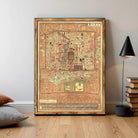 The image is a framed antique map of a city, likely from the 19th century, with intricate details and a vintage appearance.