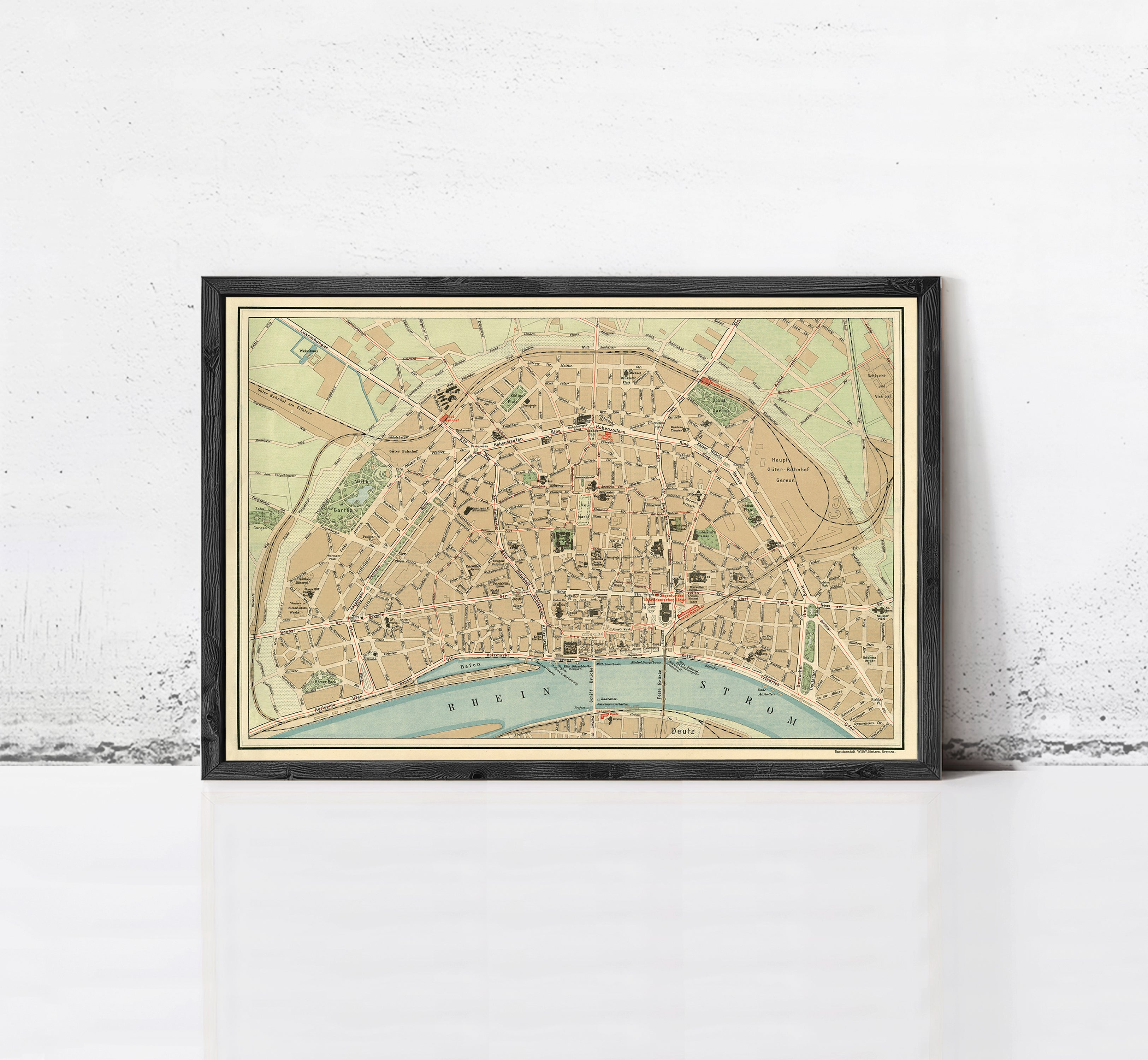 The image is a framed vintage map of a city, depicting streets, landmarks, and other geographical features.