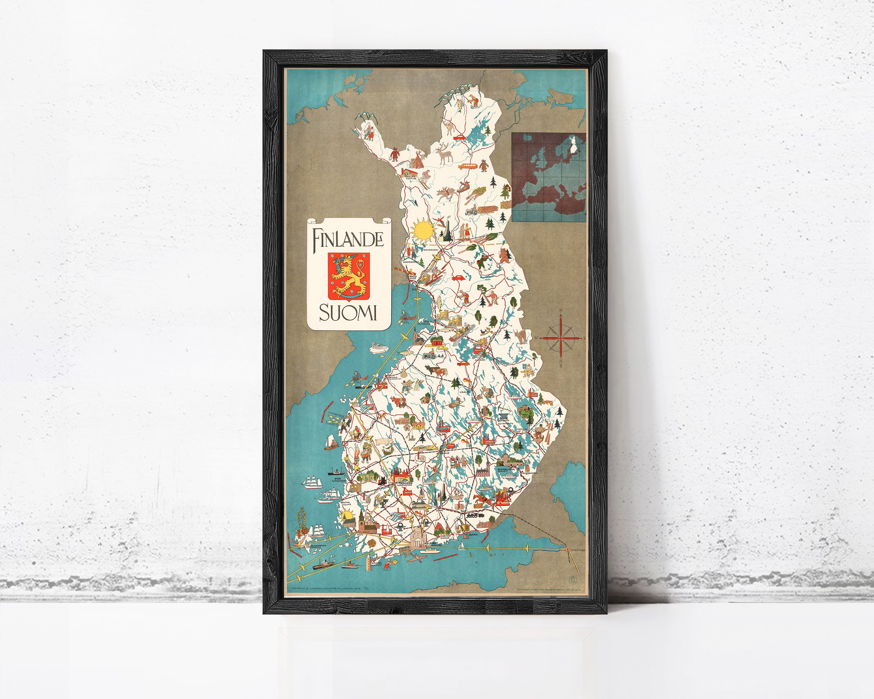 The image is a framed map of Finland, featuring various landmarks and locations throughout the country.