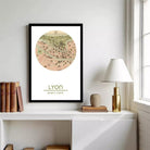 a framed map of Lyon, France, hanging on a wall above a white cabinet or shelf.