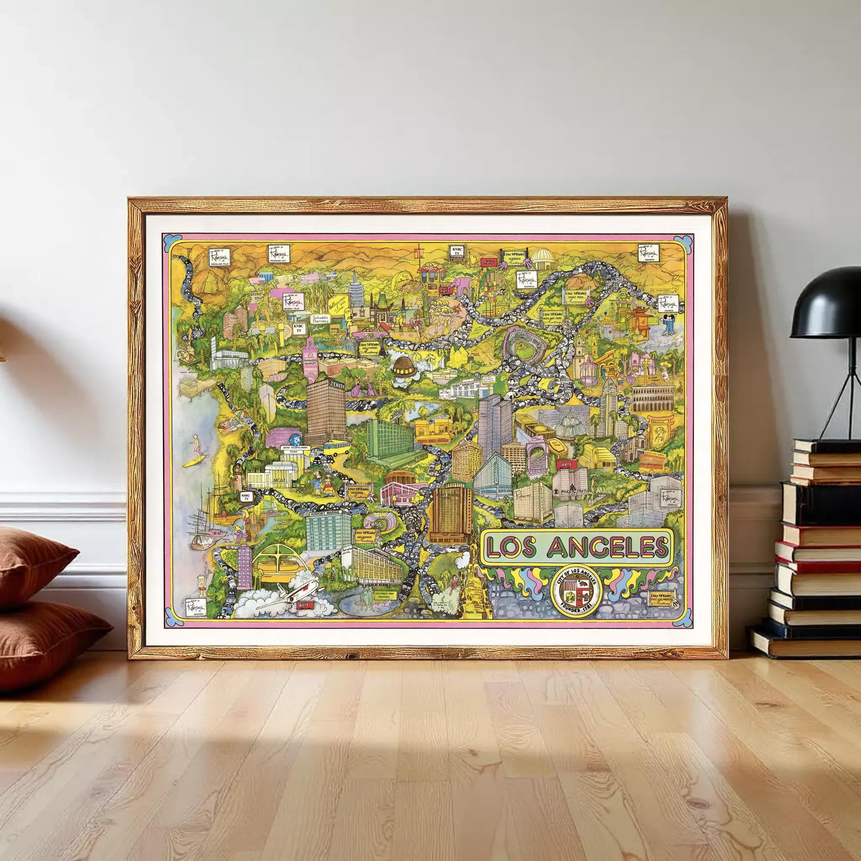 The image is a large framed map of Los Angeles, California, with various landmarks and cityscapes depicted in a colorful and detailed manner.
