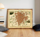 The image is a framed map of a city, likely a historical or vintage map, displayed on a wall.