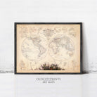 The image is a framed vintage world map with detailed illustrations and labels, displayed on a white wall.