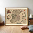 a large framed map of Ireland, with a wooden floor and a stack of books in the background.