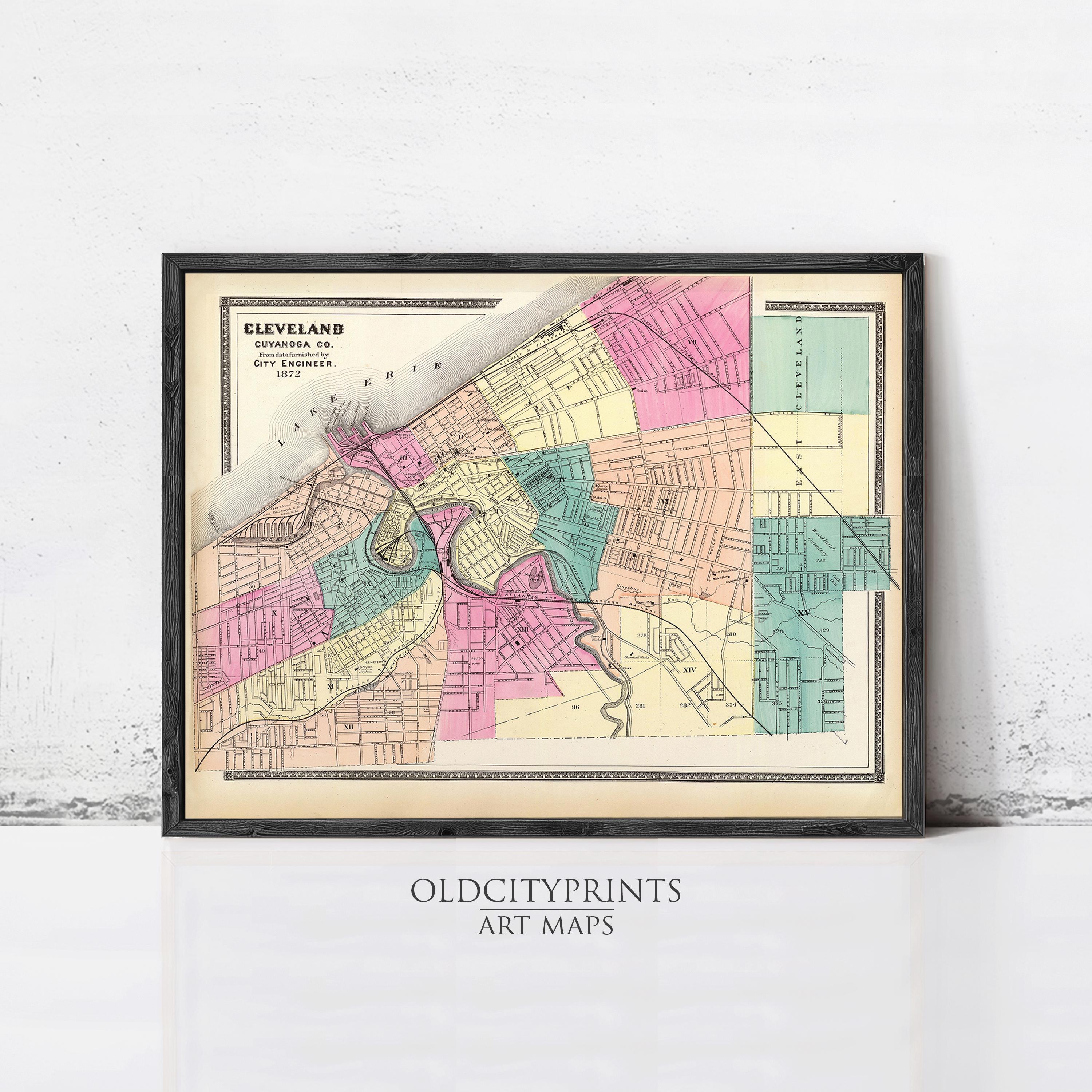 The image is a framed vintage map of Cleveland, Ohio, depicting the city's streets and neighborhoods in a colorful, detailed manner.