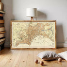 a large framed map of a city, with a lamp and some books in the background.