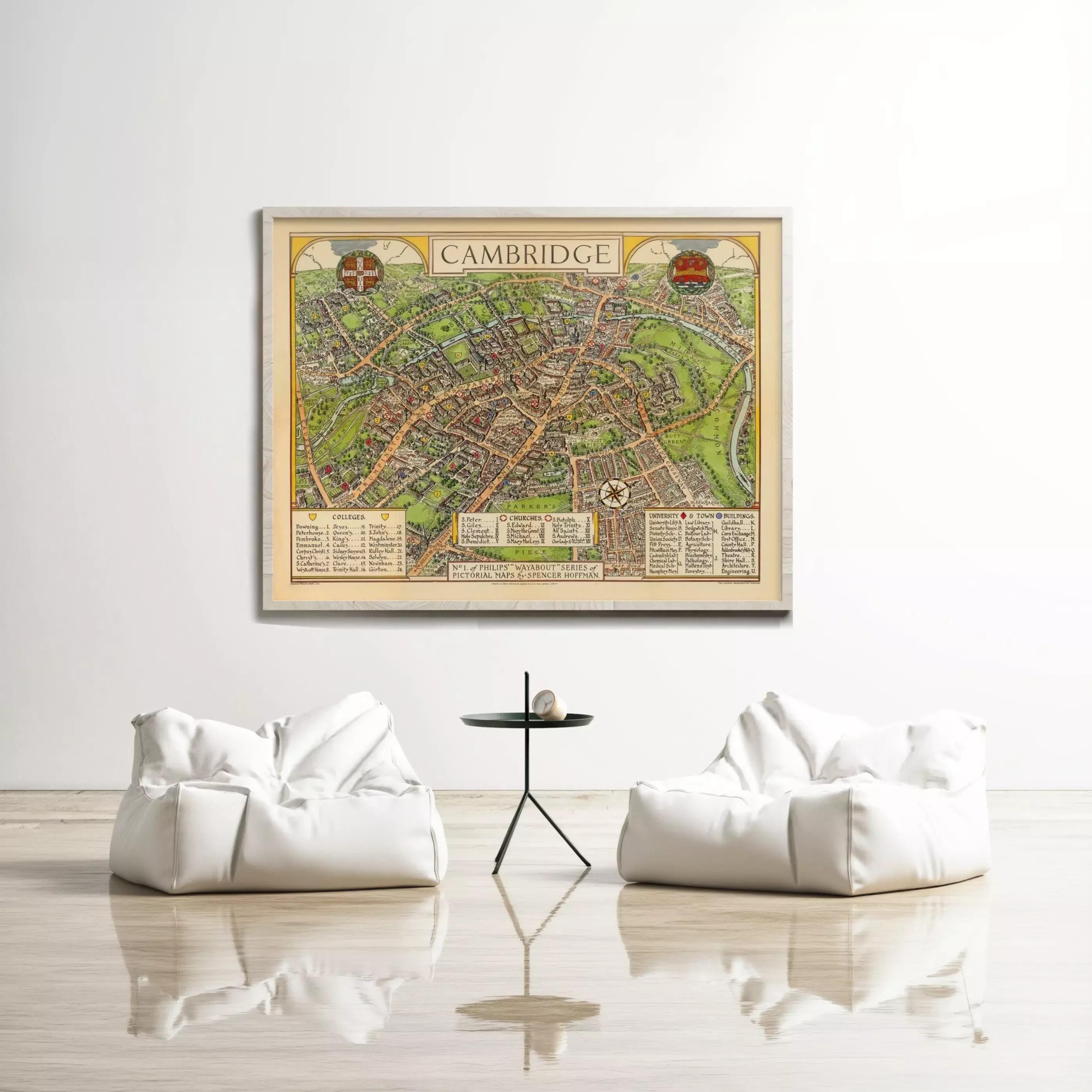 a large framed map of Cambridge hanging on a white wall, with two white bean bag chairs positioned in front of it.