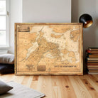a large, antique map of the city of Portsmouth, New Hampshire, with a wooden frame and a black lamp in the background.