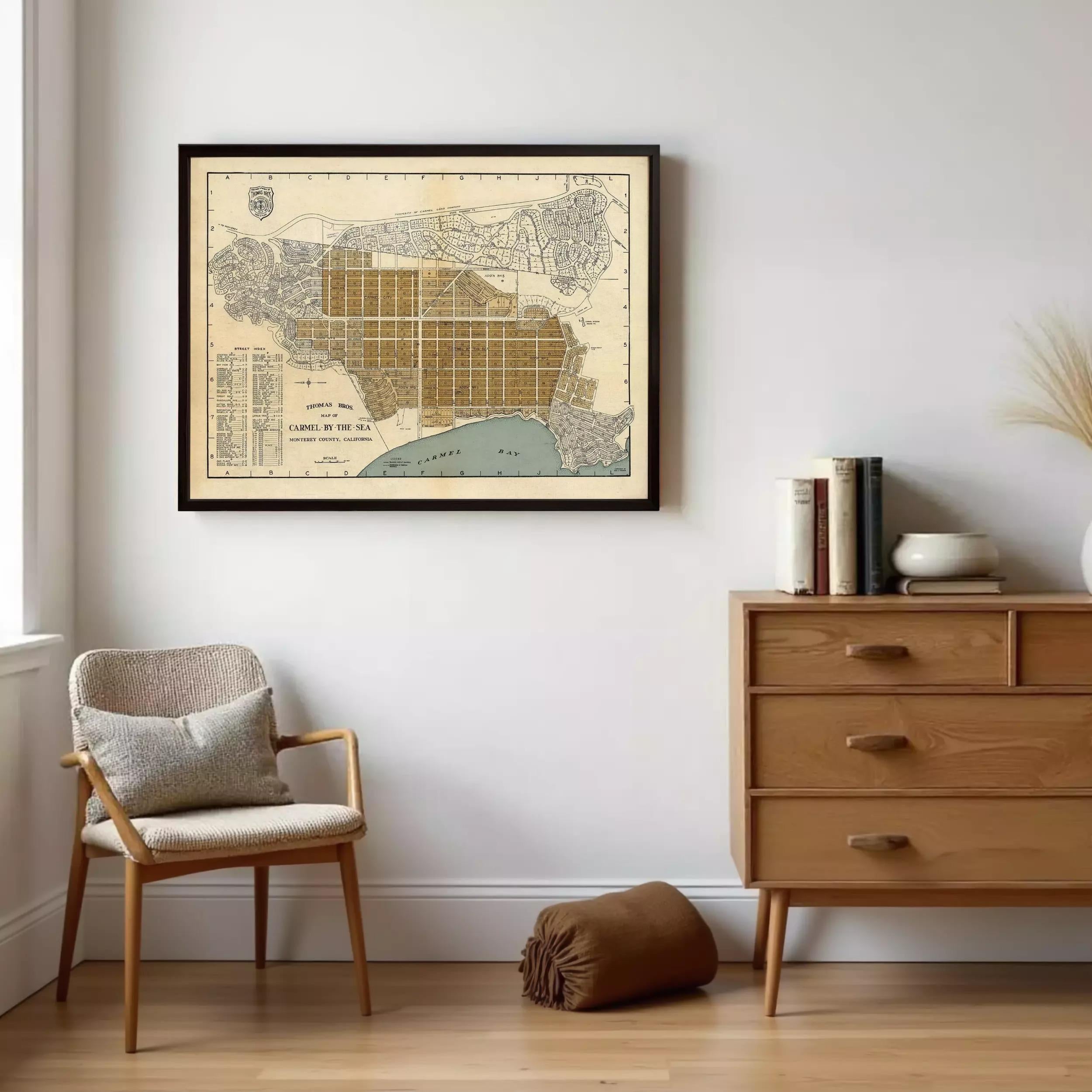 a framed map of Los Angeles, California, hanging on a wall in a room with a wooden dresser and a chair.