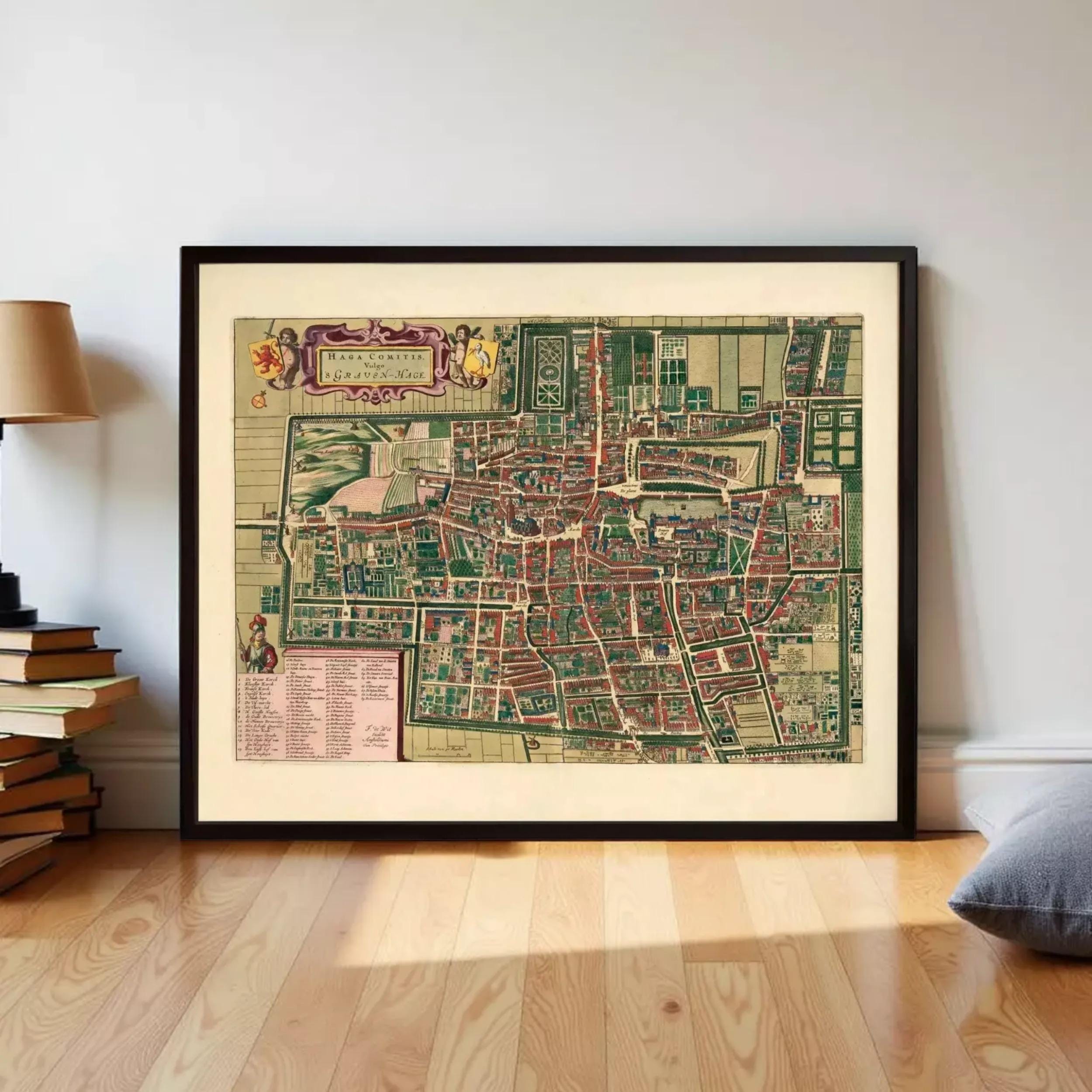 The image is a framed vintage map of a city, likely from the 16th century, displayed on a white wall.