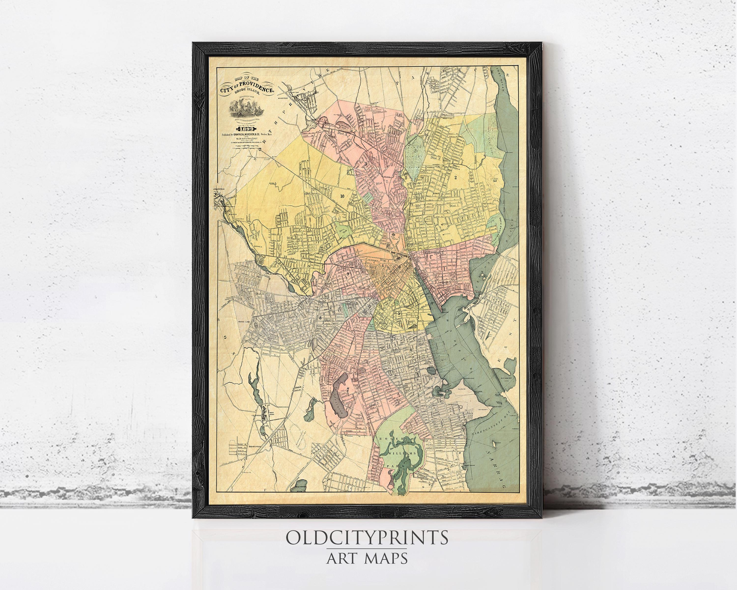 The image is a framed vintage map of a city, likely from the early 20th century, with various colored areas representing different neighborhoods or districts.