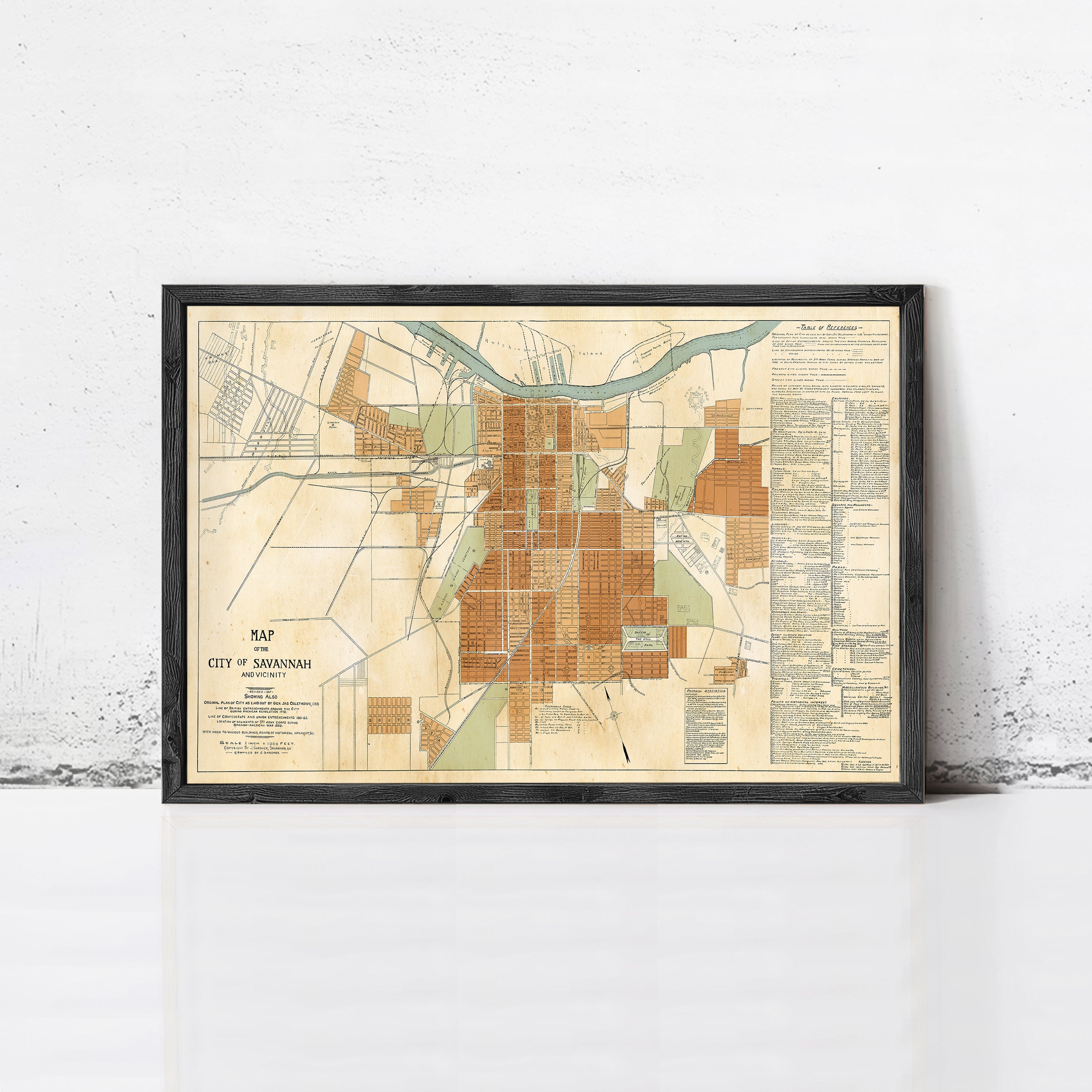 The image is a framed map of the city of Savannah, Georgia, showing the layout of the city and surrounding areas.