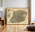 The image is a framed antique map of a city, likely from the 16th century, depicting a detailed layout of the city's streets and surrounding areas.