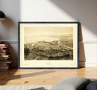 The image is a framed vintage map of a city, depicting a detailed view of the landscape and surrounding areas.