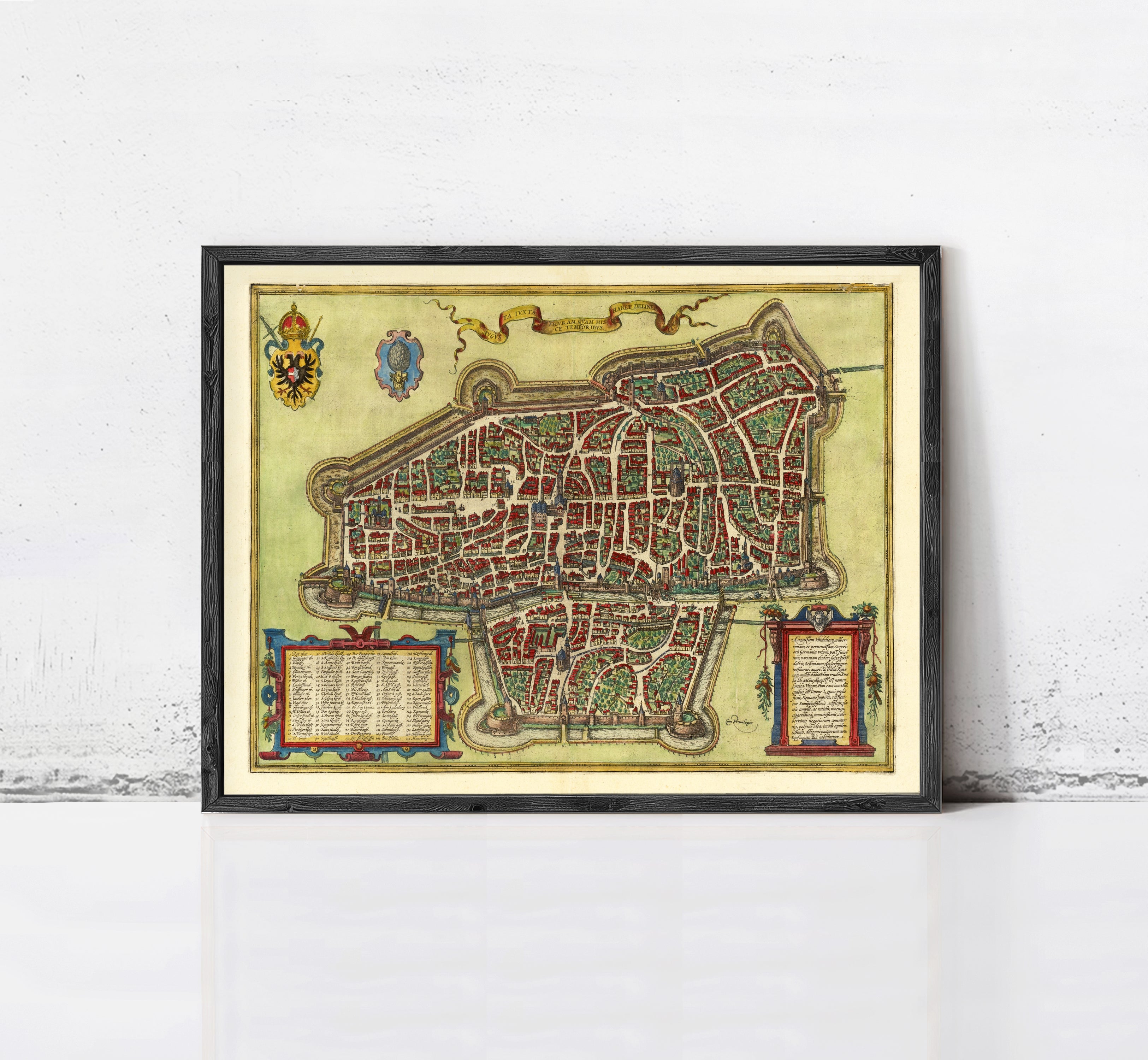 The image is a framed antique map of a city, likely from the Middle Ages, with intricate details and a decorative border.