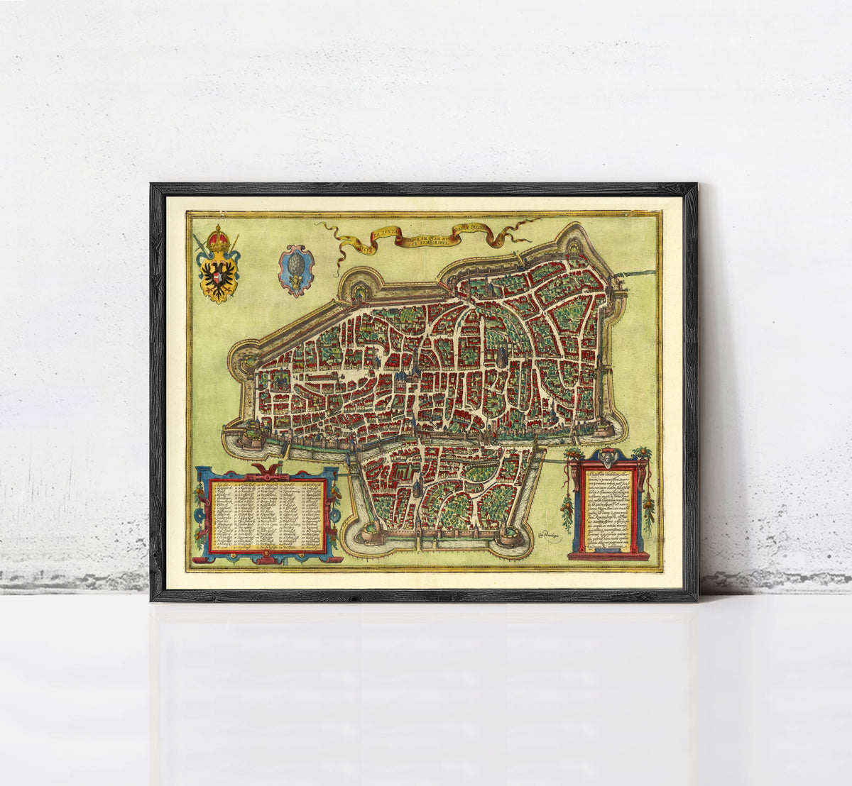 The image is a framed antique map of a city, likely from the Middle Ages, with intricate details and a decorative border.